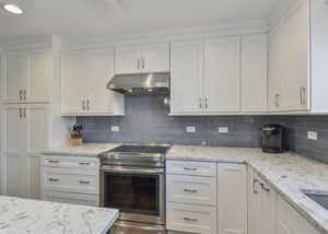 荷马格伦厨房改建项目与白色振动柜，石英台面，蓝色地铁瓷砖 -  Sebring Design Build